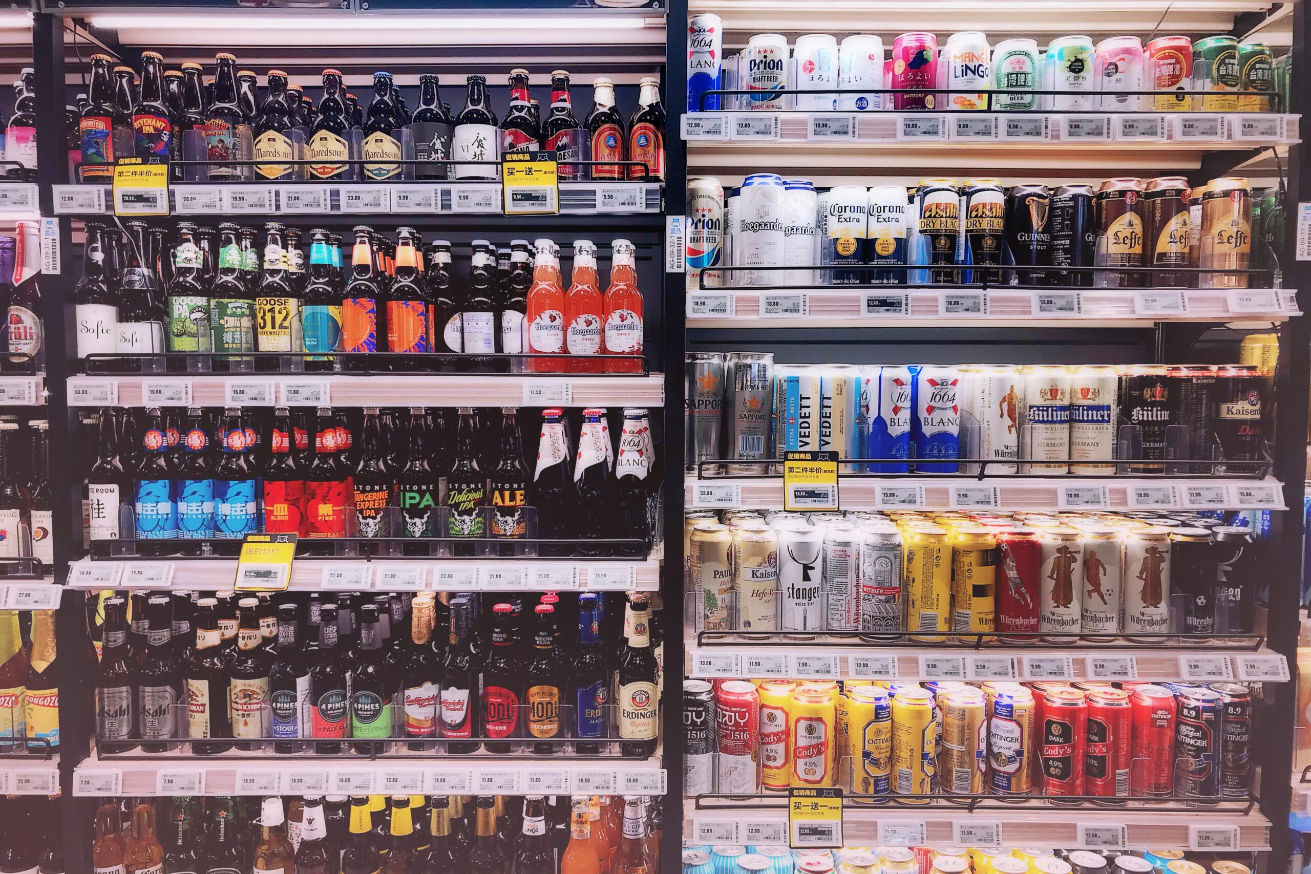 Wide variety of bottled and canned beers displayed on store shelves in Shanghai, China.